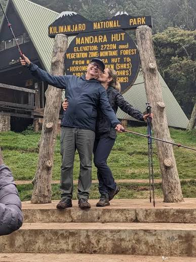 A-frame mountain hut on the Marangu Route with Kilimanjaro visible behind